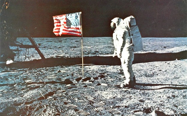 Buzz Aldrin on the moon next to the American flag